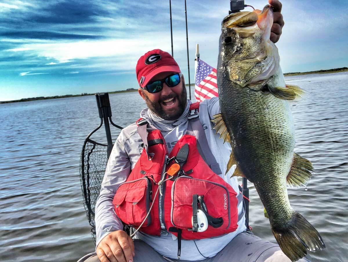 Gene Jensen catching a large mouth bass while kayak fishing. Gene Jensen catching a large mouth bass while kayak fishing.